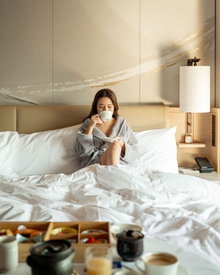 朝食とベッドにいる女性