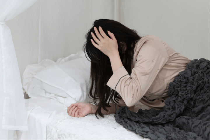 頭を押さえる女性