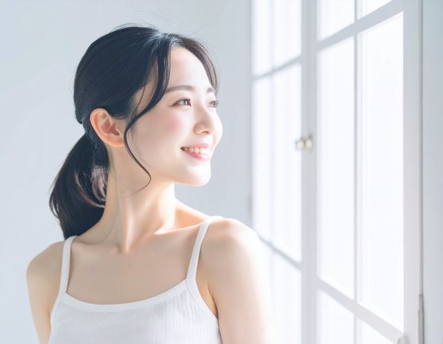 窓際で笑顔の女性
