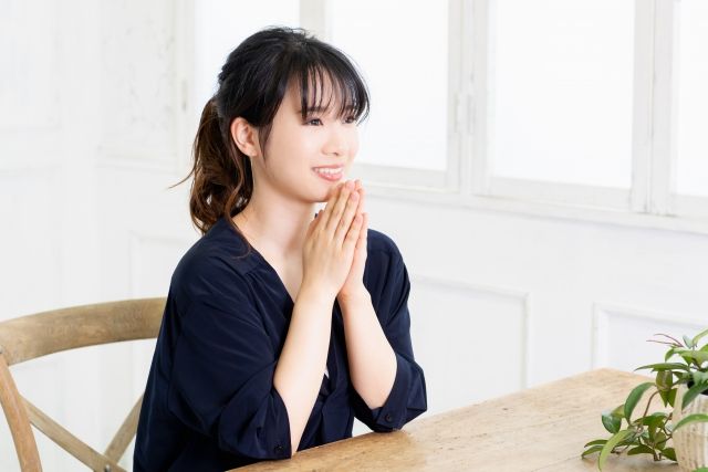 両手を合わせる女性