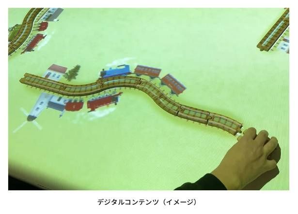木製のレールに合わせてトーマスたちの姿が投影される、インタラクティブな体験型の展示作品