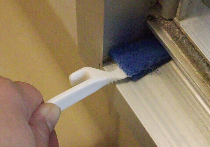 ダイソーの角の極み すきま用スティックでドアの下を掃除する様子