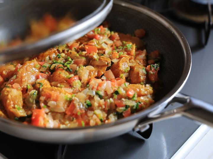 フライパンにフタをして中弱火で煮込んでいる鶏むね肉とパクチーのカレー