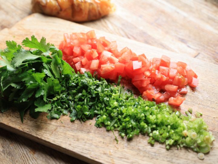 まな板に並んだ角切りのトマトとトッピング用パクチー葉・みじん切りのパクチー