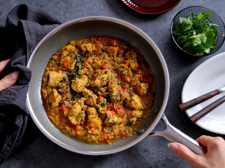 フライパンに盛られた鶏むね肉とパクチーのカレーを俯瞰で撮った完成写真