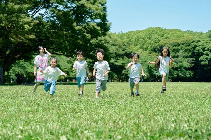走る子どもたちと見守る女性
