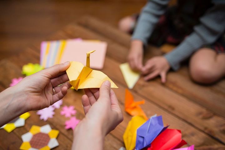 折り紙で遊ぶ親子の手