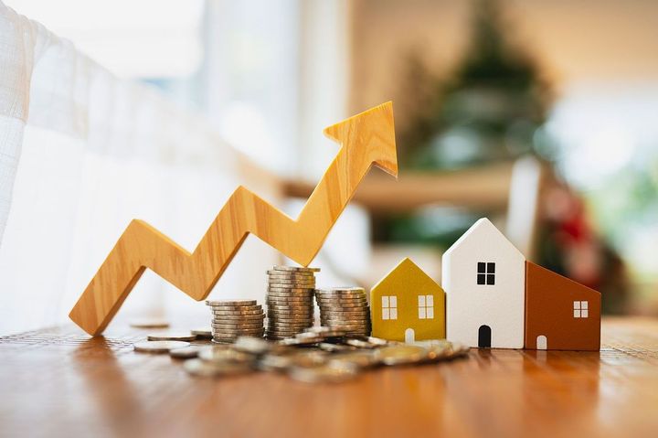 家の模型、コイン、上向きの矢印