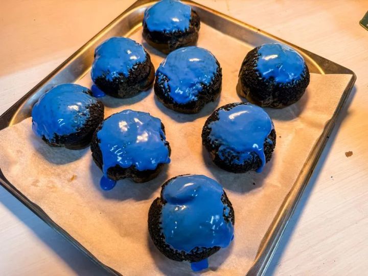 青いシュークリーム ORBIS BLUE の商品写真。黒い生地に青いクリームをのせた複数個の仕上がりが具体的にわかる画像。
