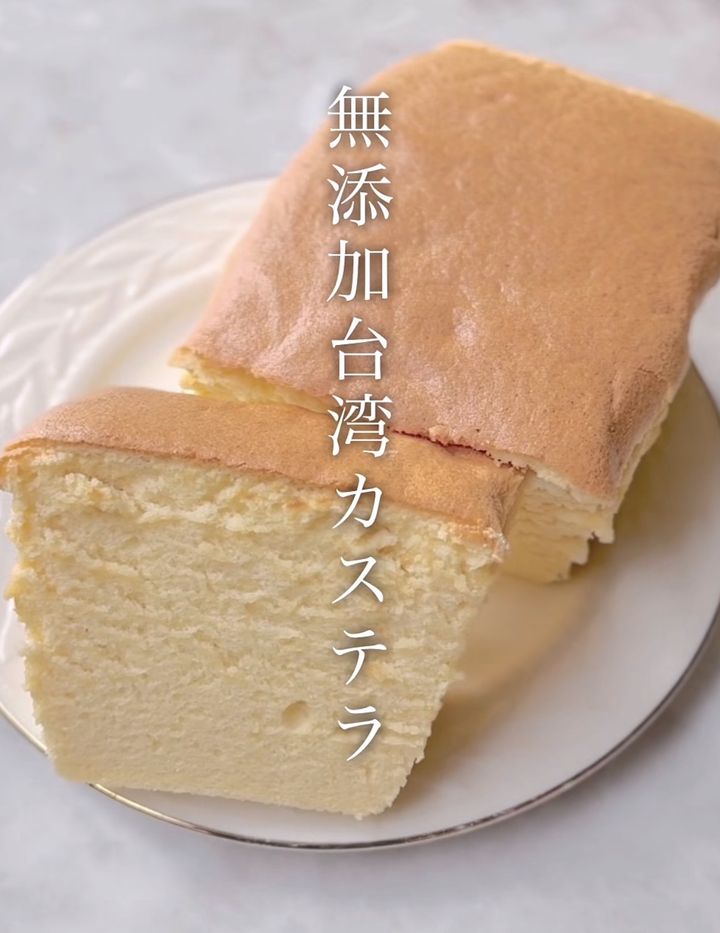 Additive-free Taiwan castella cake: a pale, fluffy slice on a plate with vertical Japanese text 無添加台湾カステラ overlaid.