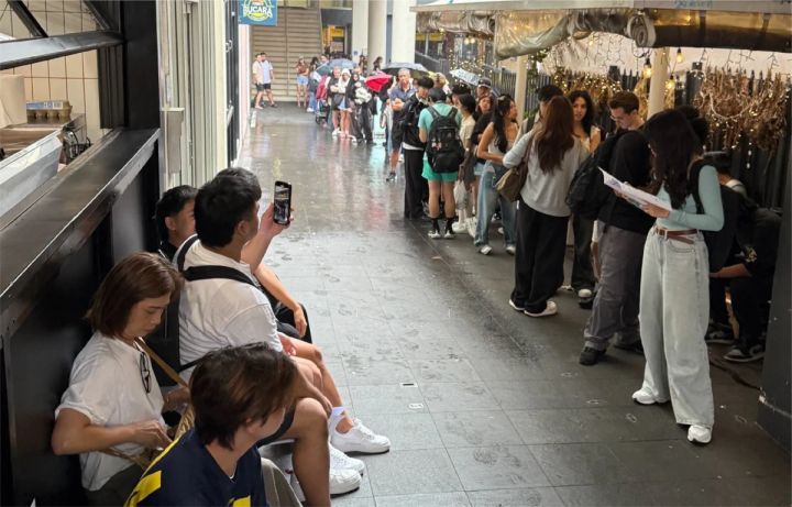 雨の中並ぶ人々