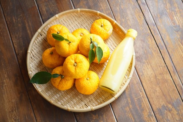 ざるに乗ったゆず複数こと、ゆず果汁の入った瓶