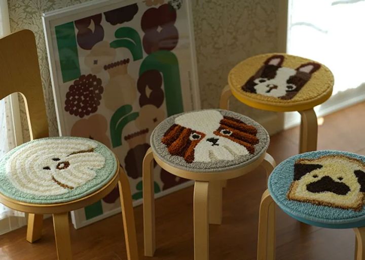 犬の顔をタフティングで表現した丸型チェアパッドを4色並べた商品ラインナップ