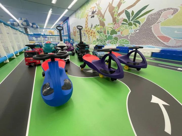 動物ジャングル壁画を背景に、メルセデスベンツ型やツイストカー型など複数の乗用玩具が並ぶカートコーナー