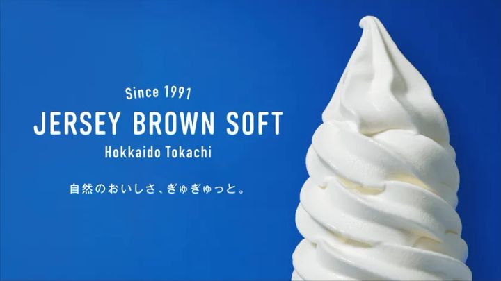十勝の緑豊かな牧場を背景にしたジャージーブラウンソフトのイメージビジュアル