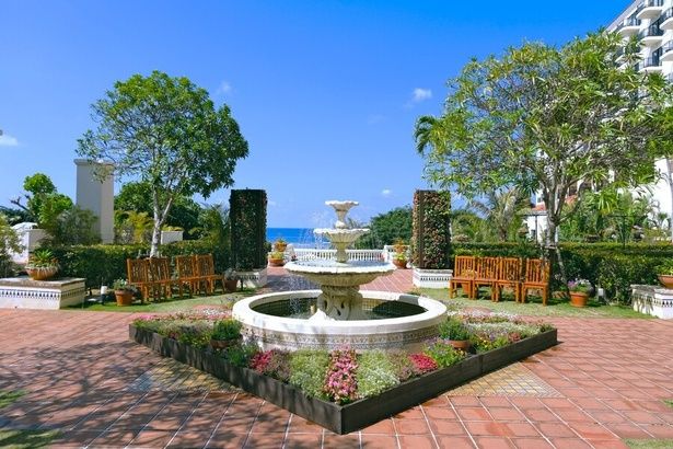 花と緑に囲まれたパティオ中央の噴水