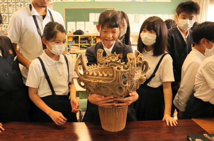 大塚オーミ陶業による小学校の出張授業で、児童が複製品に触れて学ぶ様子