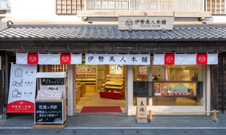 伊勢美人本舗の実店舗外観。暖簾・看板・店頭ボードに真珠・化粧品・和小物の案内が掲示され、木造町家風の建物に白暖簾が架かった店構えの全景