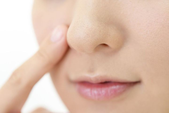 小鼻に指を添えている女性
