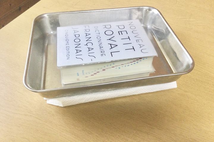 本の上にトレーと辞書をのせる