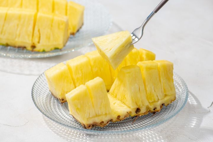 フォークを刺してカットパインを食べる