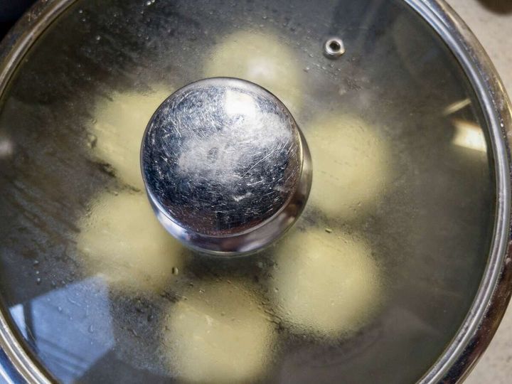 フライパンにフタをして蒸気でパン生地を蒸し焼きにしている俯瞰写真