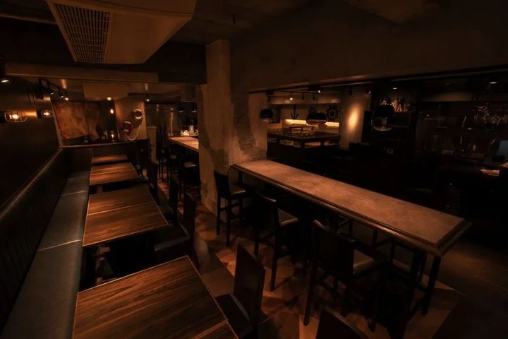 UMIバル新宿店の店内全景。ダークトーンの落ち着いた空間にボックスシートとカウンター席が並び、海をモチーフにした壁装飾とアンティーク照明が特徴の隠れ家バル内装
