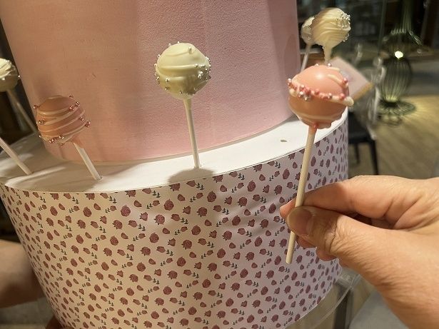 大きなタワーケーキからチョコレートロリポップを選ぶ