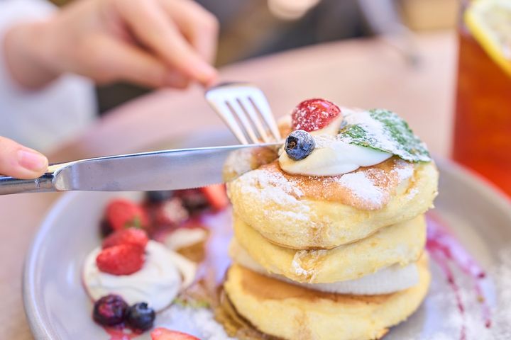 パンケーキにフォークとナイフを入れている様子
