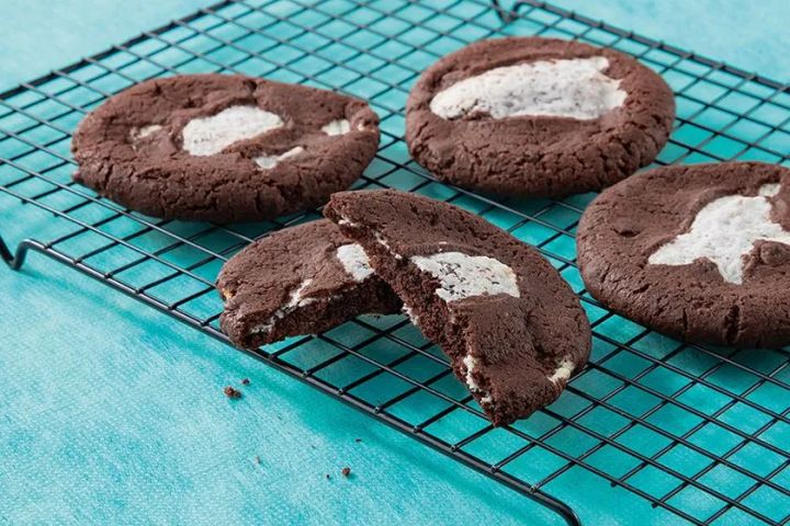 チョコレート生地にミントクリームを包んだ厚焼きクッキー4枚をクーリングラックに並べ、1枚を割って断面のクリーム層を見せた商品写真