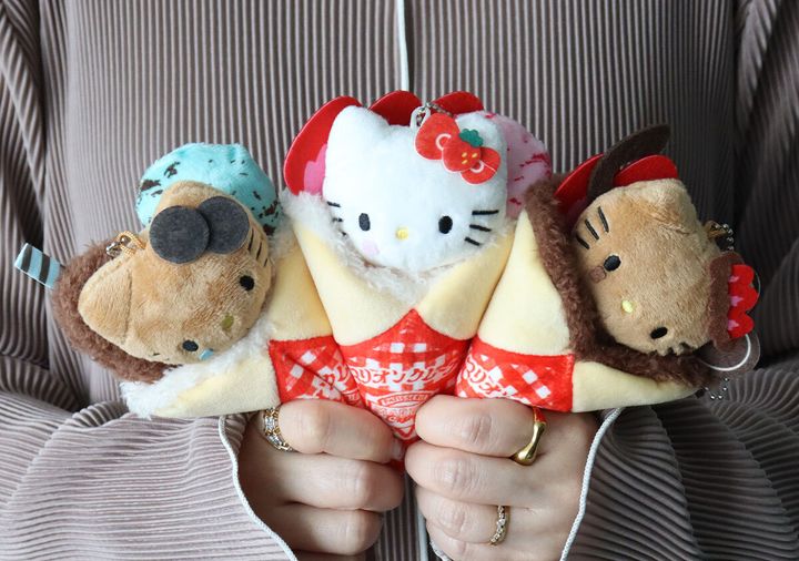 全3種類のマリオンクレープ×HELLO KITTYぬいぐるみチャームを両手で持つ様子