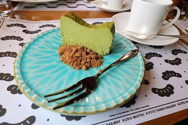 「天橋立の緑景 抹茶チーズケーキ」。海を思わせる青い皿に、松並木をイメージした自家製の抹茶チーズケーキ。クッキーを砕いたクランブルで砂浜を表現している