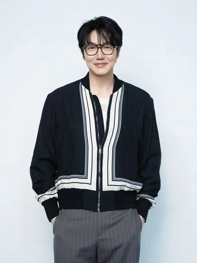 ソン・シギョンの白背景スタジオ撮影の上半身ポートレート。黒×白ストライプのジャケット着用、眼鏡をかけた正面向き公式プロフィール写真