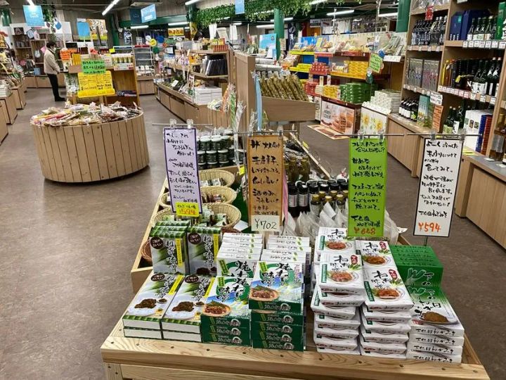 道の駅しもにたの物産館売り場全景。下仁田ねぎ味噌・ねぎ炒め味噌など地域特産品がパッケージ商品として棚に積まれ、手書きPOPで価格と産地説明が付記された陳列台
