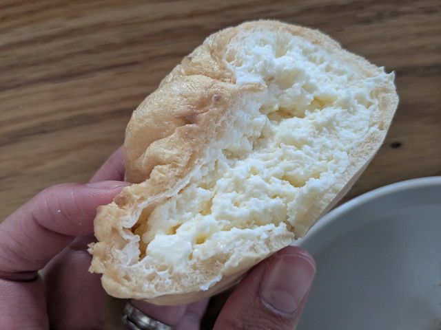 もちむにシューを割った断面。ふわふわの白いミルククリームがたっぷり詰まっている
