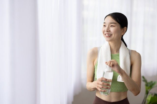 ペットボトルの水を持つ女性