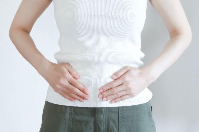 腹部に手を添える女性