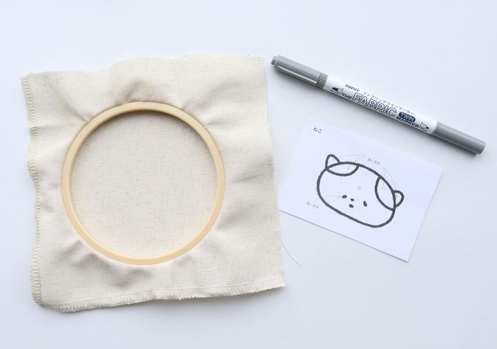 刺しゅう枠の布にチャコペンでねこ図案を写す準備の様子