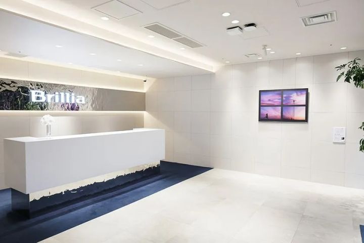 Brillia Galleryの白基調インテリア内に写真アート作品1点を壁掛け展示したギャラリー内観。受付カウンターとBrilliaロゴが正面に見える