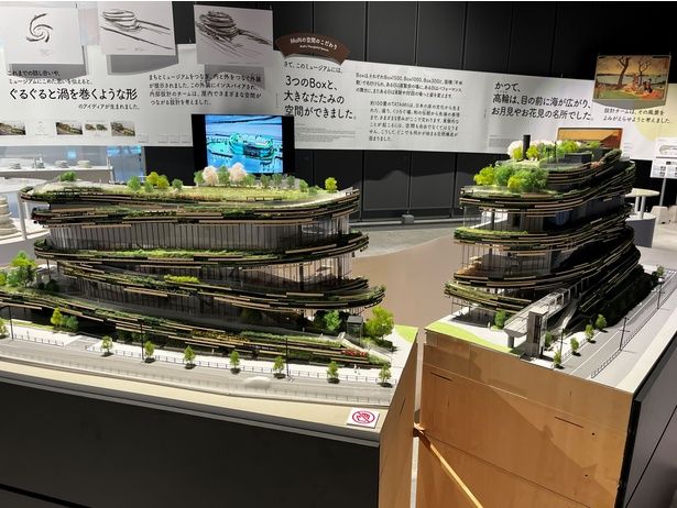 「ひらけ モン！展」で公開された精巧な建築模型。各フロアを緑が巡り、らせん状にうねる外装設計は、隈研吾さんがこの地の風景と文化からインスパイアされたもの