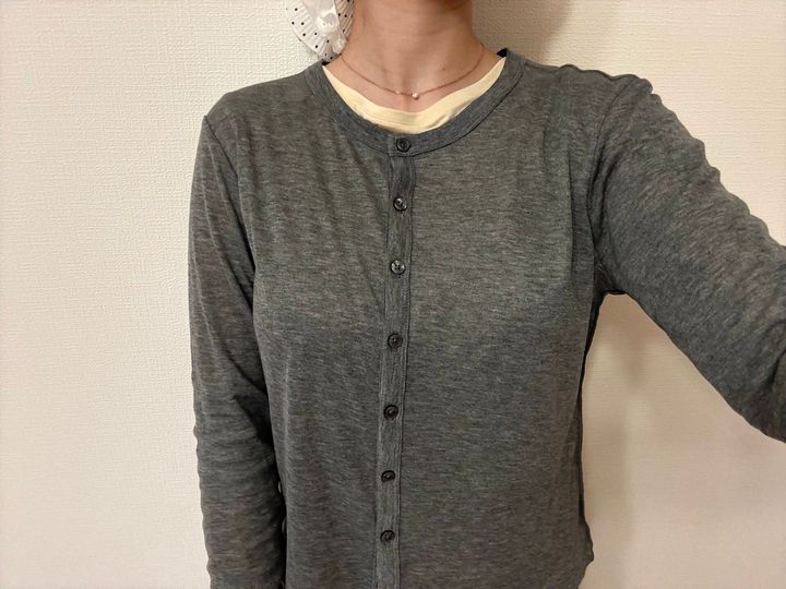 グレーのシアートップスの下に淡いイエローのインナーを忍ばせた差し色コーデ。