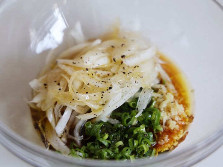ガラスボウルに新玉ねぎ、小ねぎ、しょうが、めんつゆ、黒こしょうを合わせた様子