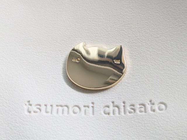 ツモリチサトのがま口ポシェットのゴールドネコモチーフとブランドロゴのエンボス加工アップ