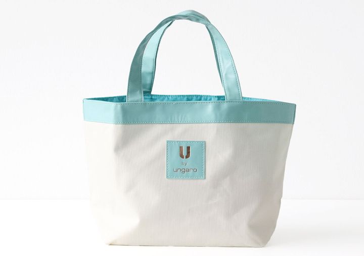 オフホワイト生地にエメラルドブルーの縁取りと持ち手、U by ungaroのロゴタグが付いた舟形トートバッグの全体