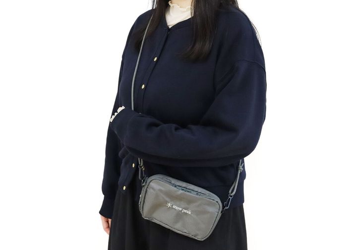 ネイビーのジャケットと白いハイネックの女性がsnow peakのグレーお財布ショルダーを斜め掛けした着用イメージ