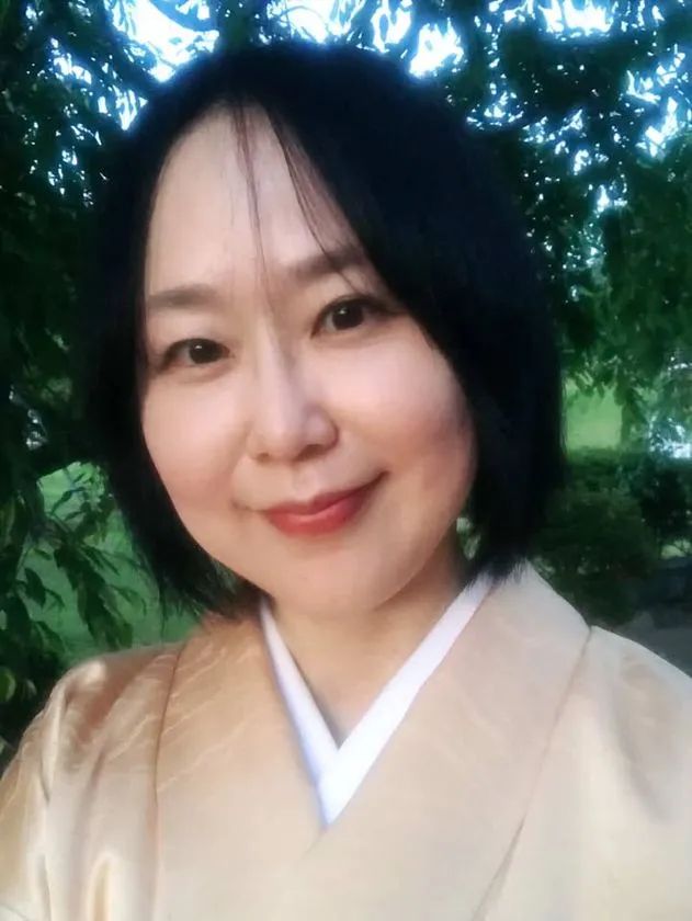 淡金色の着物を着用した女性の上半身・顔アップ写真。茶道インストラクターまたは講師役と思われる人物紹介用ポートレート