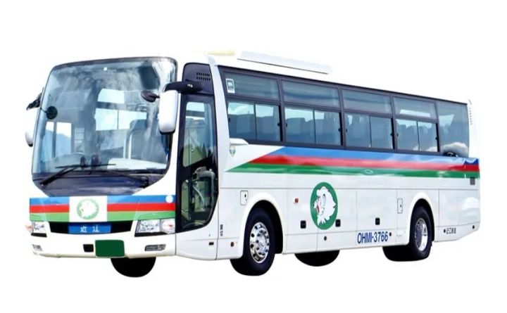 近江トラベルの観光バス（OHMI-3766）の車体写真。白地に青・赤・緑のライン入りで近江カモシカのロゴが側面に描かれた中型バス
