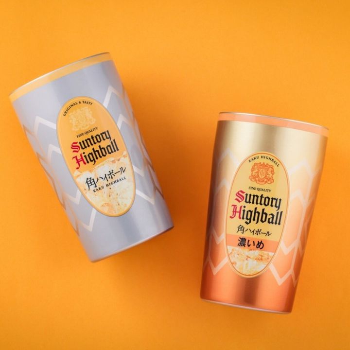 オレンジ背景に、角ハイボール缶デザインのシルバー基調スタンダードと銅色基調濃いめver.の真空断熱タンブラー2本が並ぶ俯瞰写真