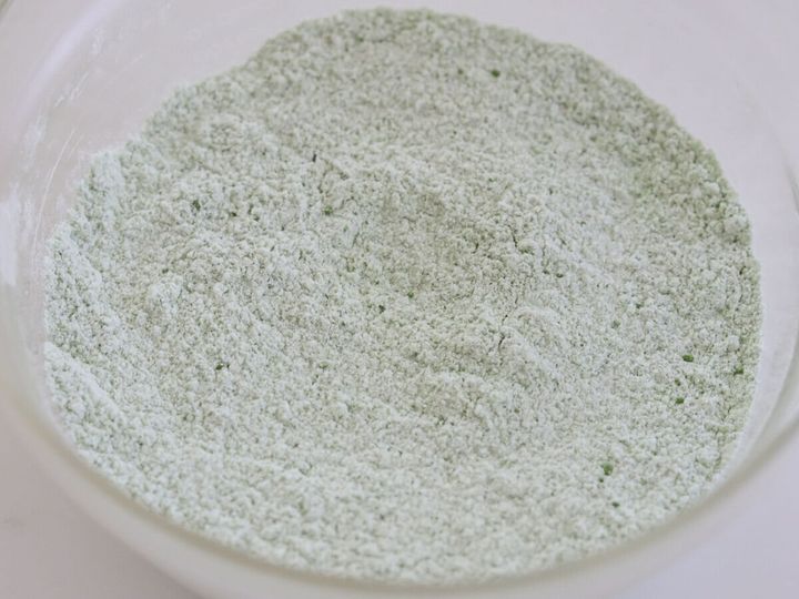 ガラスボウルに米粉・アーモンドプードル・抹茶・ベーキングパウダーを入れて混ぜ合わせた抹茶色の粉類の俯瞰写真