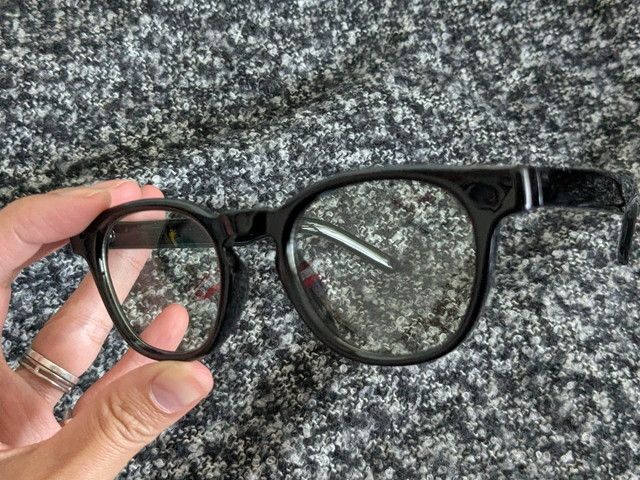 調光グラス ブラックを手に持ったアップ。クリアなレンズとツヤのあるブラックフレーム